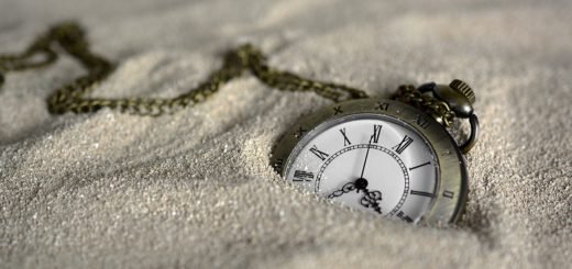 pocket watch buried in sand